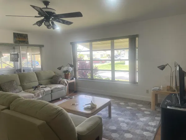 a living room with furniture a chandelier and a window