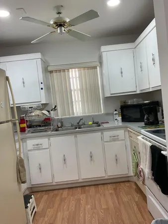 a kitchen with granite countertop a sink stainless steel appliances and cabinets