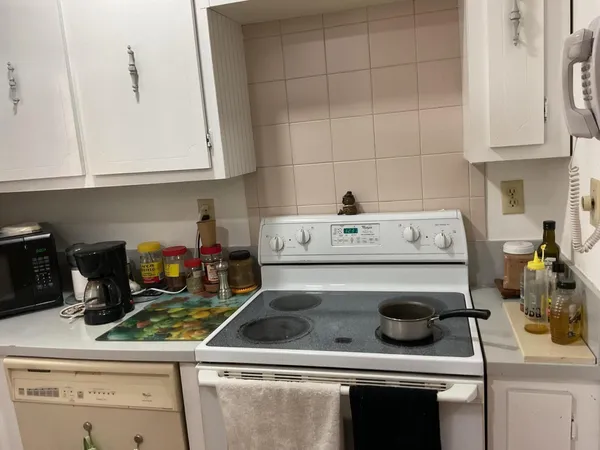 a kitchen with a stove and a white cabinets