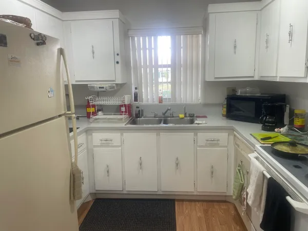 a kitchen with white cabinets and white appliances