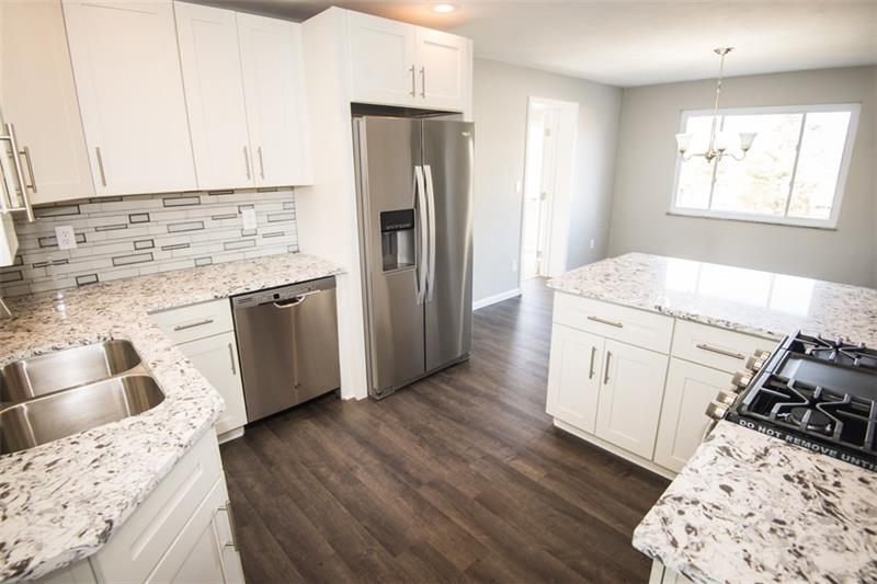 218 McClure Road Cheswick, PA 15024 - Photo 10 of 25 Kitchen with quartz counters, stainless appliances, mosaic glass backsplash, and brand new cabinets.