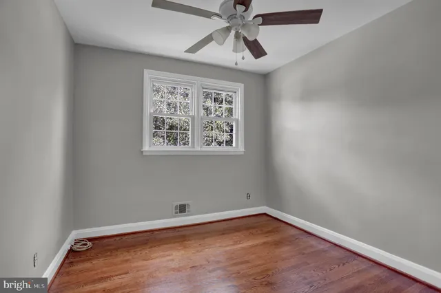 an empty room with a window and a fan