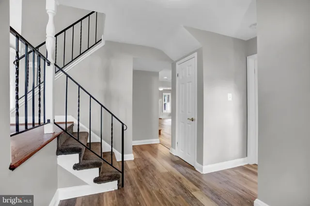 a view of staircase with wooden floor and white walls