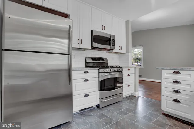 a kitchen with white cabinets and white appliances