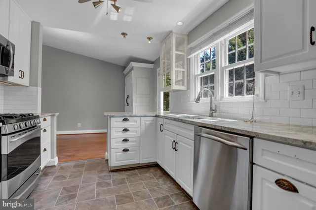 a kitchen with granite countertop a sink stove and cabinets