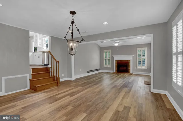 a view of empty room with wooden floor and fireplace