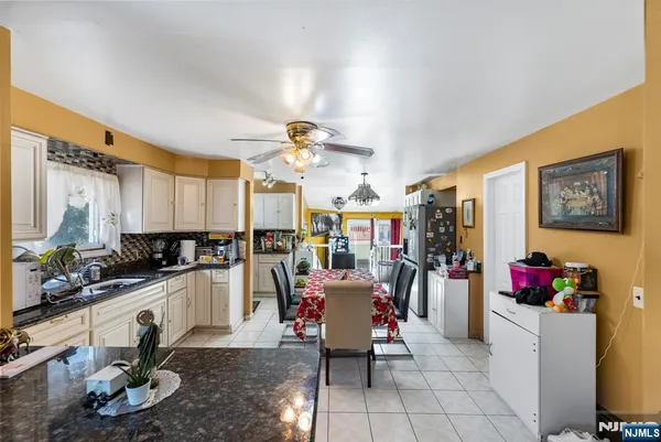 a living room with furniture a chandelier and a dining table