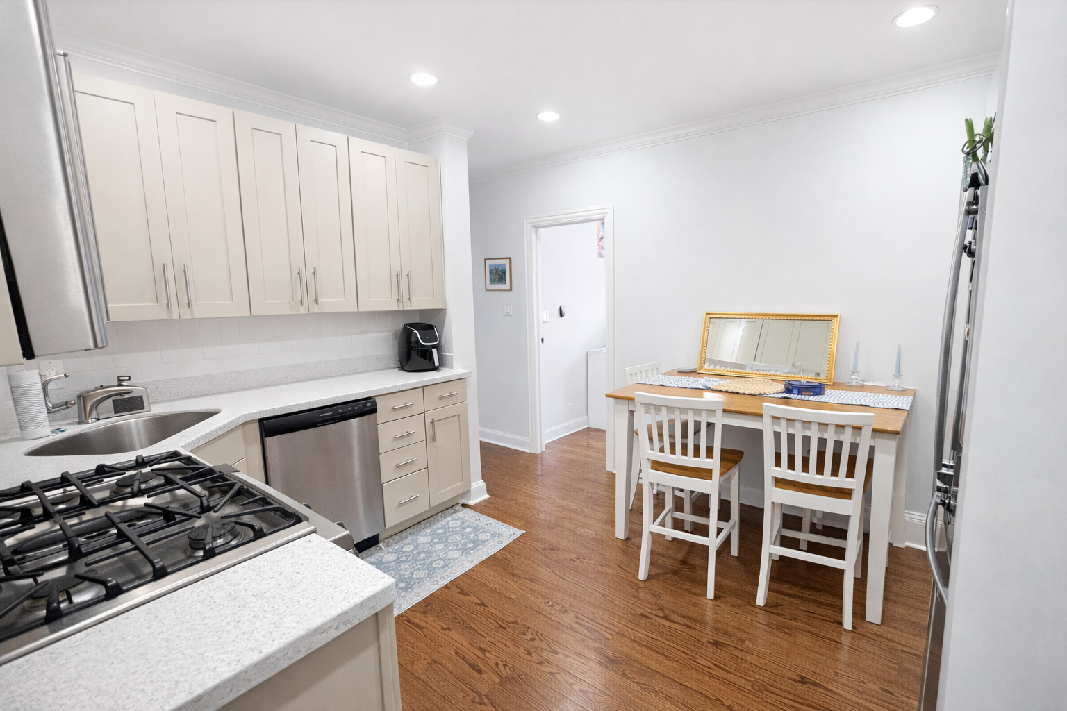 2467 North Clark Street, Unit 3 Chicago, IL 60614 - Photo 2 of 8 a kitchen with a stove a refrigerator and a dining table