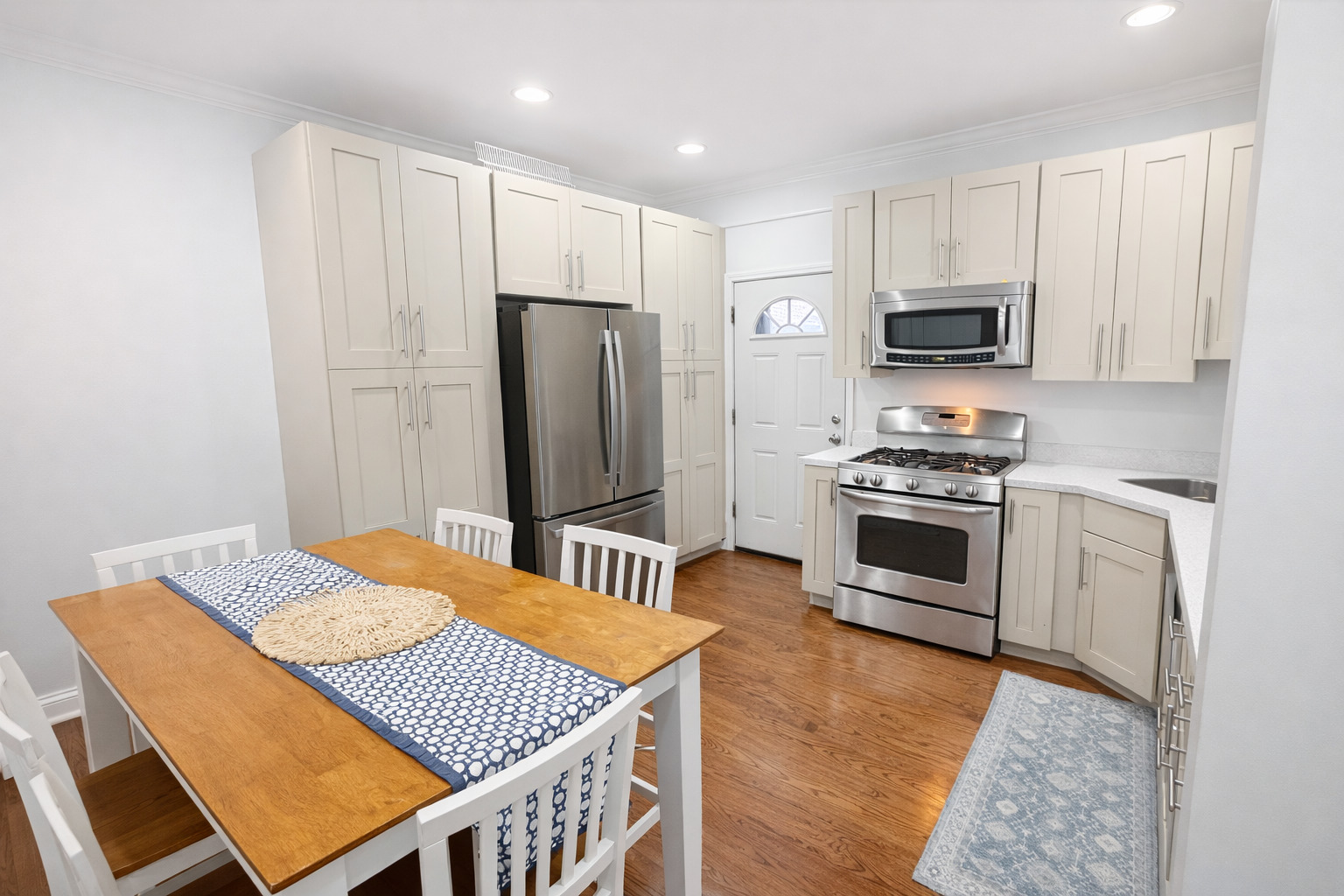 2467 North Clark Street, Unit 3 Chicago, IL 60614 - Photo 3 of 8 a kitchen with stainless steel appliances a refrigerator a stove a sink cabinets and a dining table