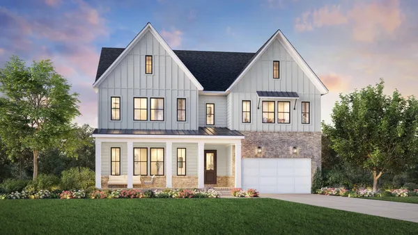 a front view of a house with a yard and trees