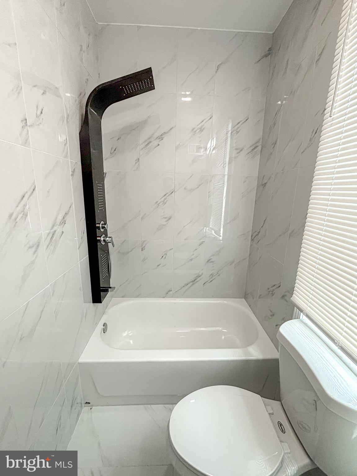 3631 Reed Street Philadelphia, PA 19146 - Photo 14 of 21 a bathroom with a white bath tub a toilet and a sink