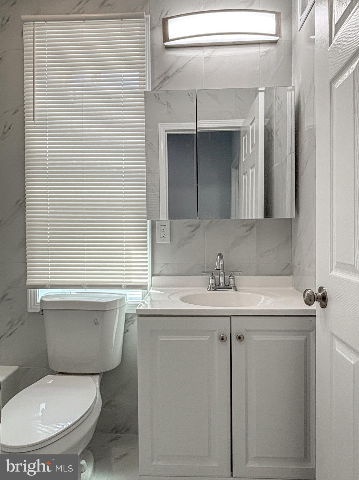 3631 Reed Street Philadelphia, PA 19146 - Photo 15 of 21 a bathroom with a toilet sink and mirror