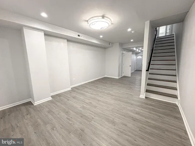 an empty room with wooden floor and entryway
