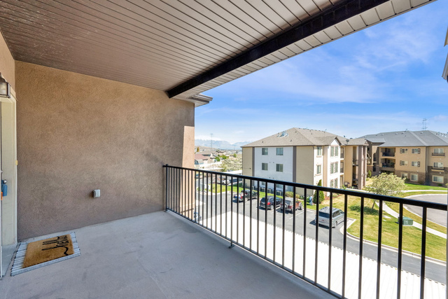 8215 Clear Rock Road, Unit 12 Eagle Mountain, UT 84005 - Photo 38 of 38 Private balcony featuring stucco exterior, a concrete floor, and black metal railings