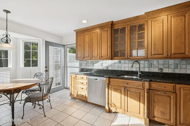 a kitchen with granite countertop wooden cabinets chairs and granite counter tops