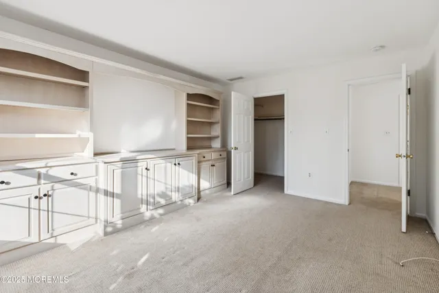 an empty room with white walls and windows