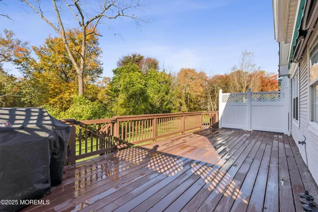 a view of deck with wooden floor and fence with a bench