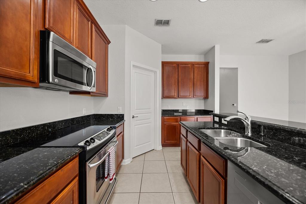 7719 Anselmo Lane Windermere, FL 34786 - Photo 11 of 31 a kitchen with granite countertop a sink stove and microwave