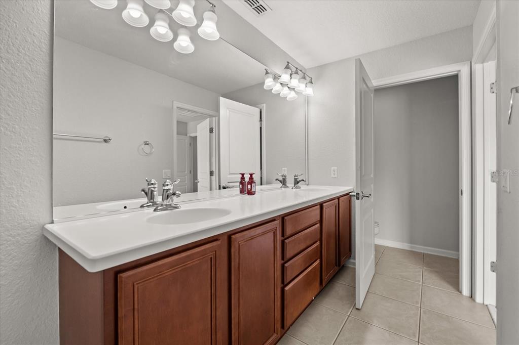 7719 Anselmo Lane Windermere, FL 34786 - Photo 18 of 31 a bathroom with a double vanity sink and a mirror