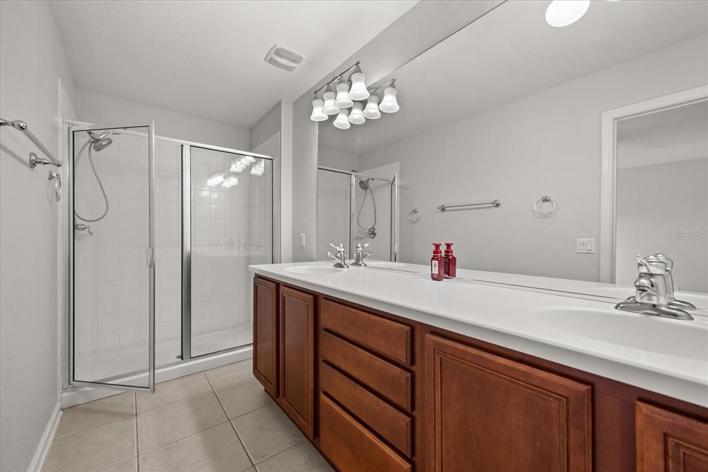 7719 Anselmo Lane Windermere, FL 34786 - Photo 19 of 31 a bathroom with a double vanity sink and a mirror