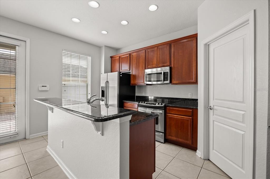 7719 Anselmo Lane Windermere, FL 34786 - Photo 10 of 31 a kitchen with kitchen island granite countertop appliances cabinets and a counter top space