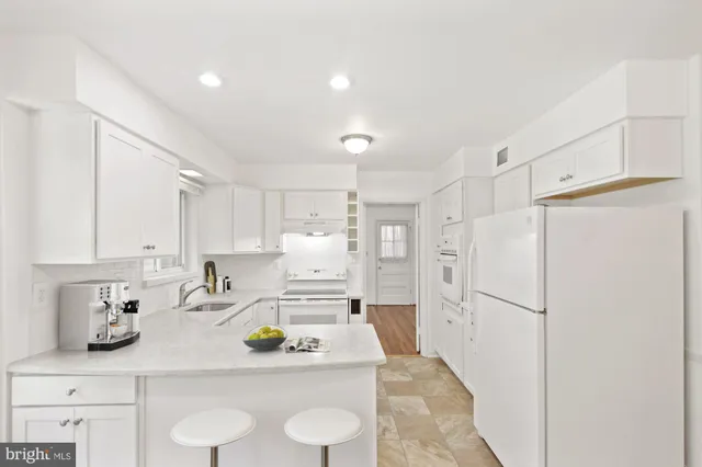 a kitchen with stainless steel appliances a refrigerator sink and white cabinets