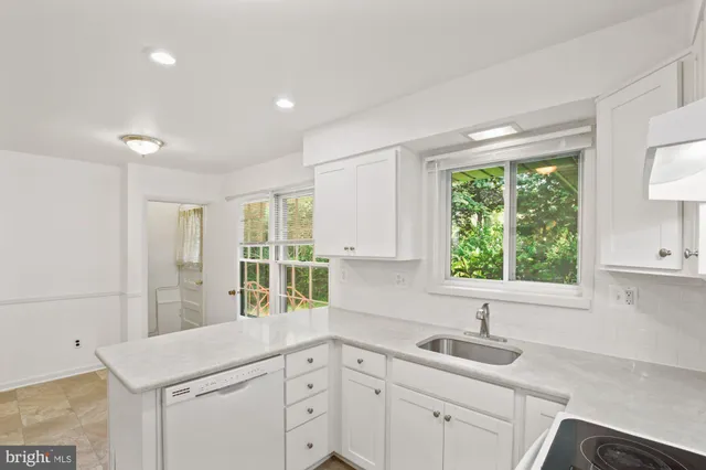 a kitchen with a sink window and cabinets