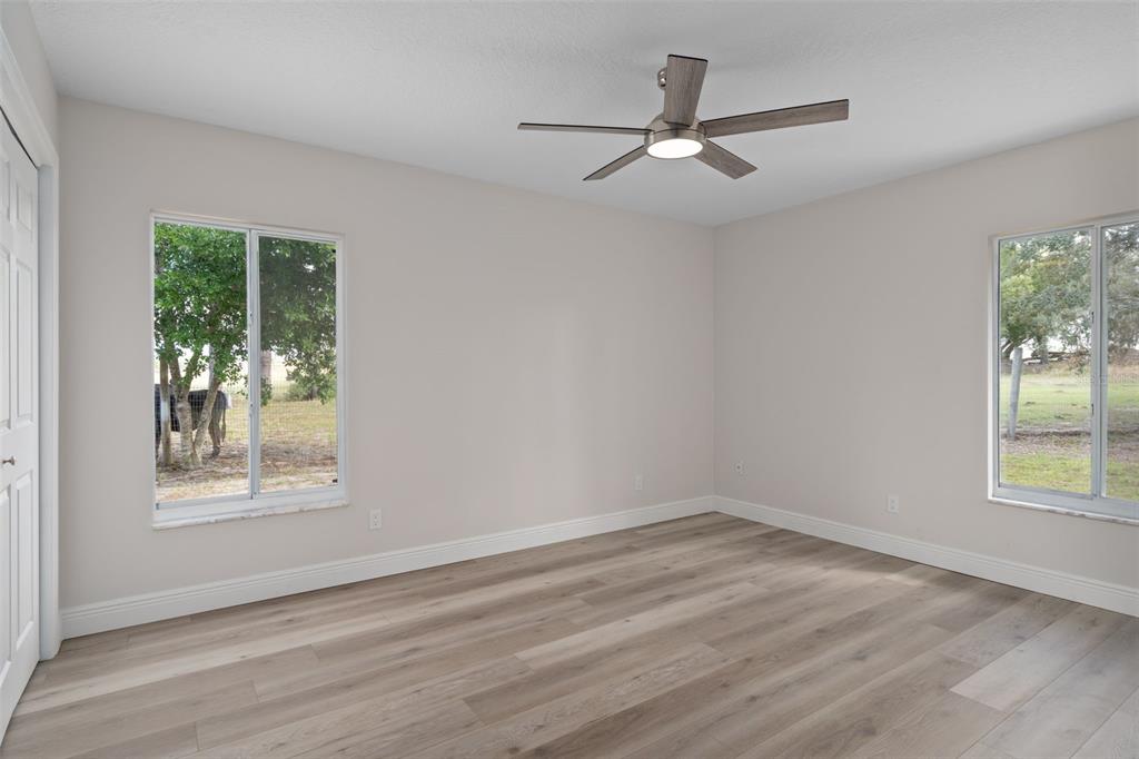 10352 Brentlawn Street Spring Hill, FL 34608 - Photo 17 of 35 a view of an empty room with wooden floor and a window