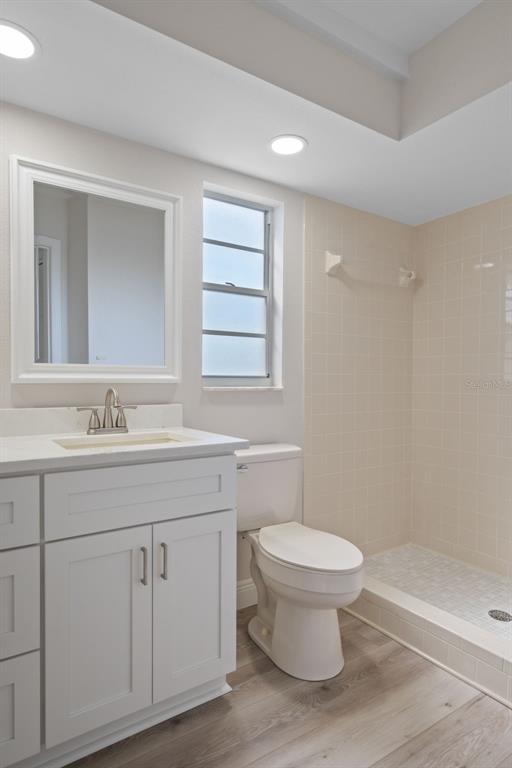 10352 Brentlawn Street Spring Hill, FL 34608 - Photo 21 of 35 a bathroom with a granite countertop toilet a sink a mirror a window and vanity