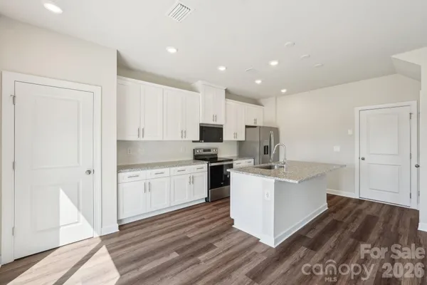 a kitchen with a sink stainless steel appliances and white cabinets