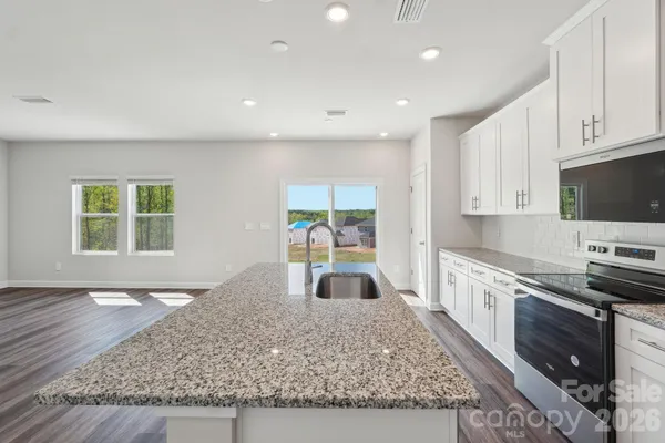 a large kitchen with stainless steel appliances granite countertop a stove a sink and a granite counter tops