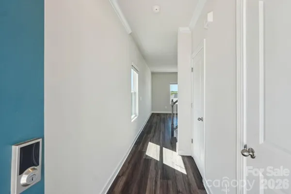 a view of a hallway with wooden floor and staircase