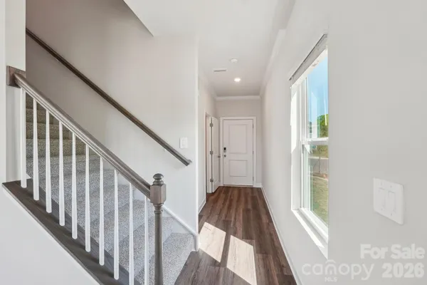a view of a hallway with wooden floor and staircase