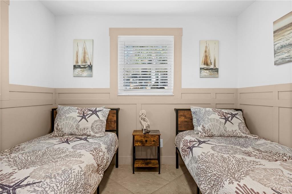 723 Park Avenue Naples, FL 34110 - Photo 17 of 48 a bedroom with a bed and wooden floor