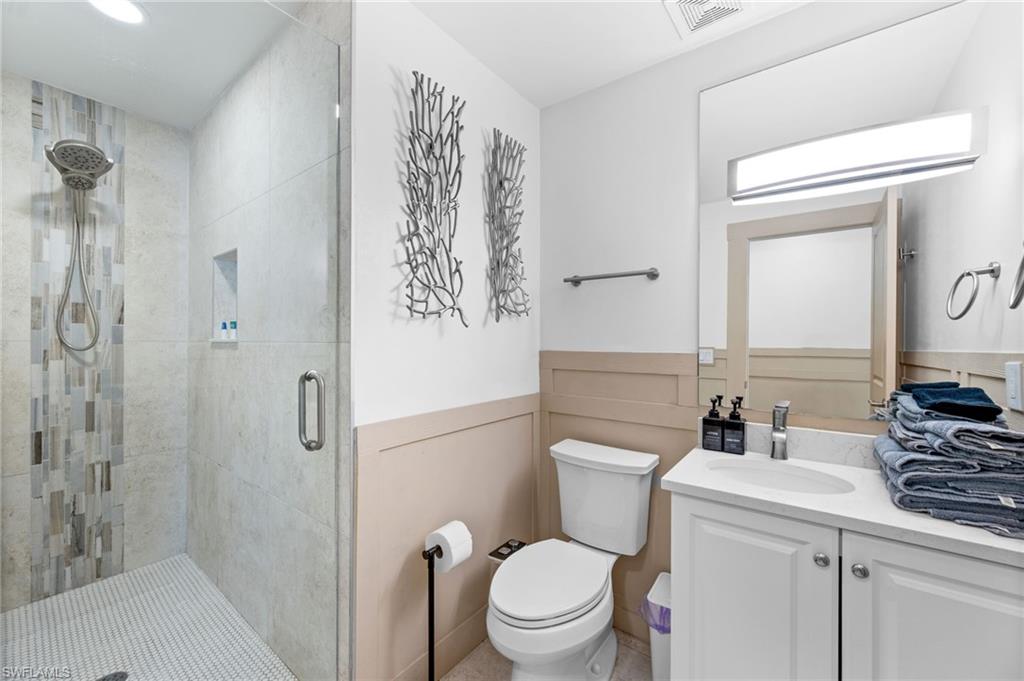 723 Park Avenue Naples, FL 34110 - Photo 25 of 48 a bathroom with a toilet sink vanity and shower
