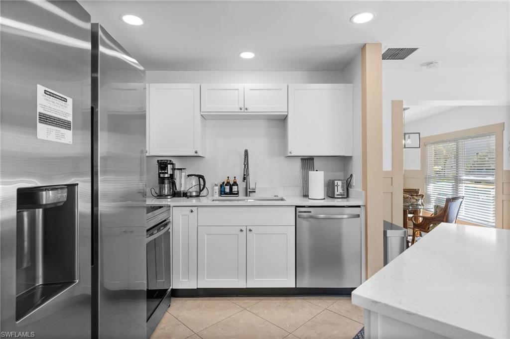 723 Park Avenue Naples, FL 34110 - Photo 31 of 48 a kitchen with stainless steel appliances granite countertop a refrigerator sink and cabinets