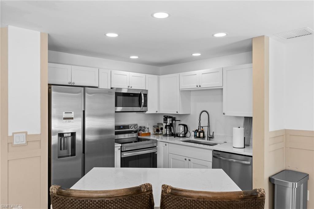 723 Park Avenue Naples, FL 34110 - Photo 33 of 48 a kitchen with a refrigerator a sink a stove a microwave and cabinets