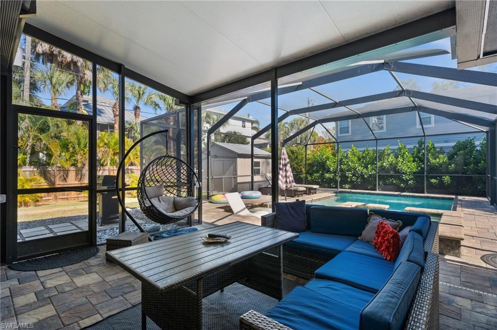 723 Park Avenue Naples, FL 34110 - Photo 42 of 48 a outdoor living room with furniture a rug and a floor to ceiling window