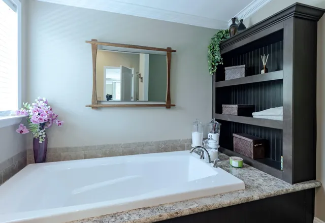 a bathroom with a tub sink and mirror