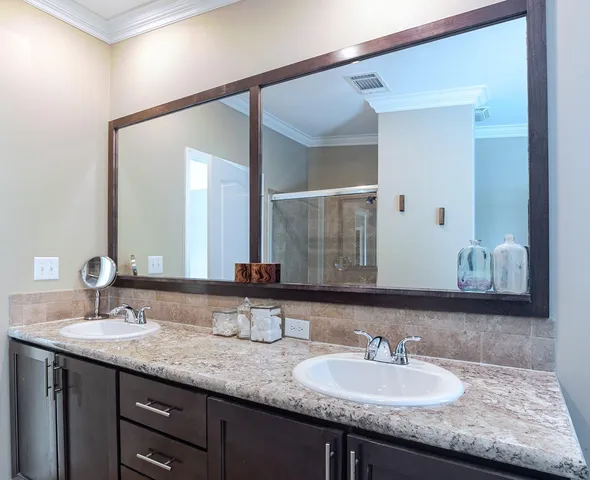 a bathroom with double vanity sinks and a mirror