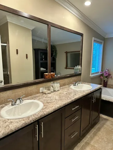 a bathroom with a granite countertop sink double and mirror
