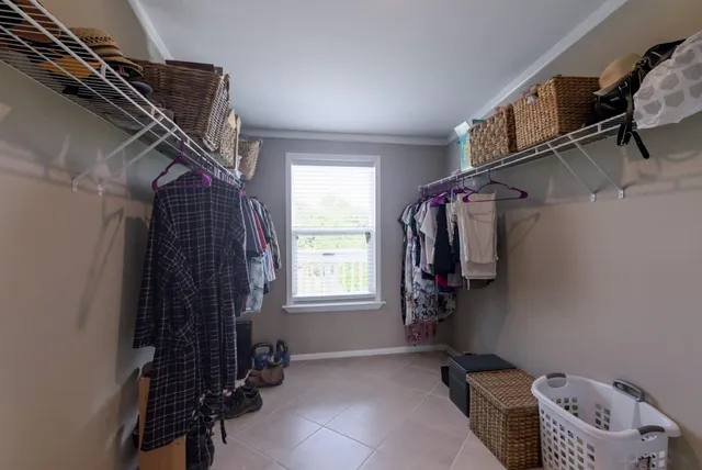 a view of walk in closet with clothes and shoes