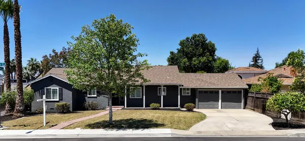 a front view of a house with a yard and potted plants