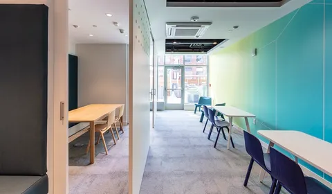 a kitchen with stainless steel appliances a table and chairs in it