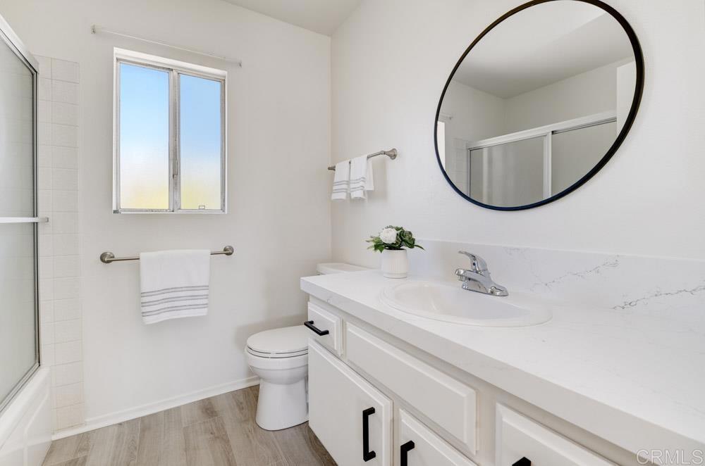 3573 Evening Canyon Road Oceanside, CA 92056 - Photo 28 of 45 a bathroom with a sink a mirror a toilet and a window