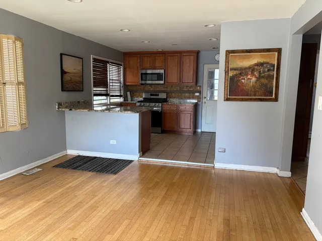 a kitchen with granite countertop a stove top oven a sink and a microwave