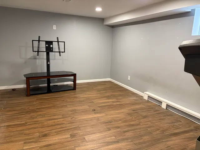 a view of empty room with wooden floor