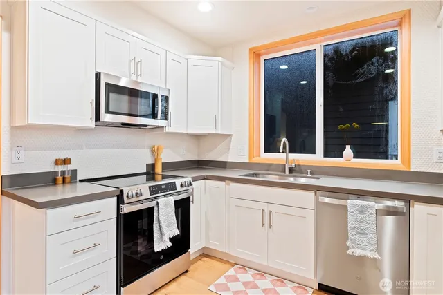 a kitchen with white cabinets stainless steel appliances and sink