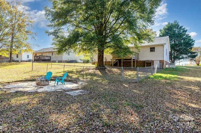 a view of a house with backyard and a tree