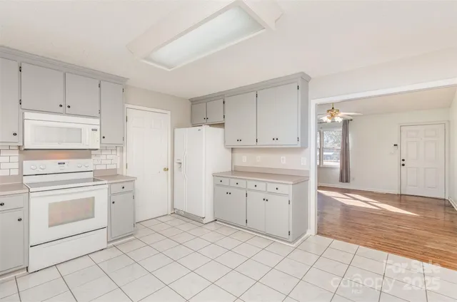 a kitchen with white cabinets and white appliances